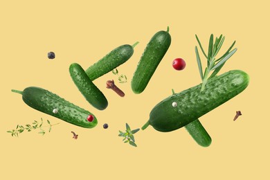 Image of Ripe cucumbers, herbs and spices flying on pale orange background