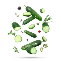 Image of Ripe cucumbers, herbs and spices falling on white background