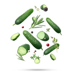 Image of Ripe cucumbers, herbs and spices falling on white background