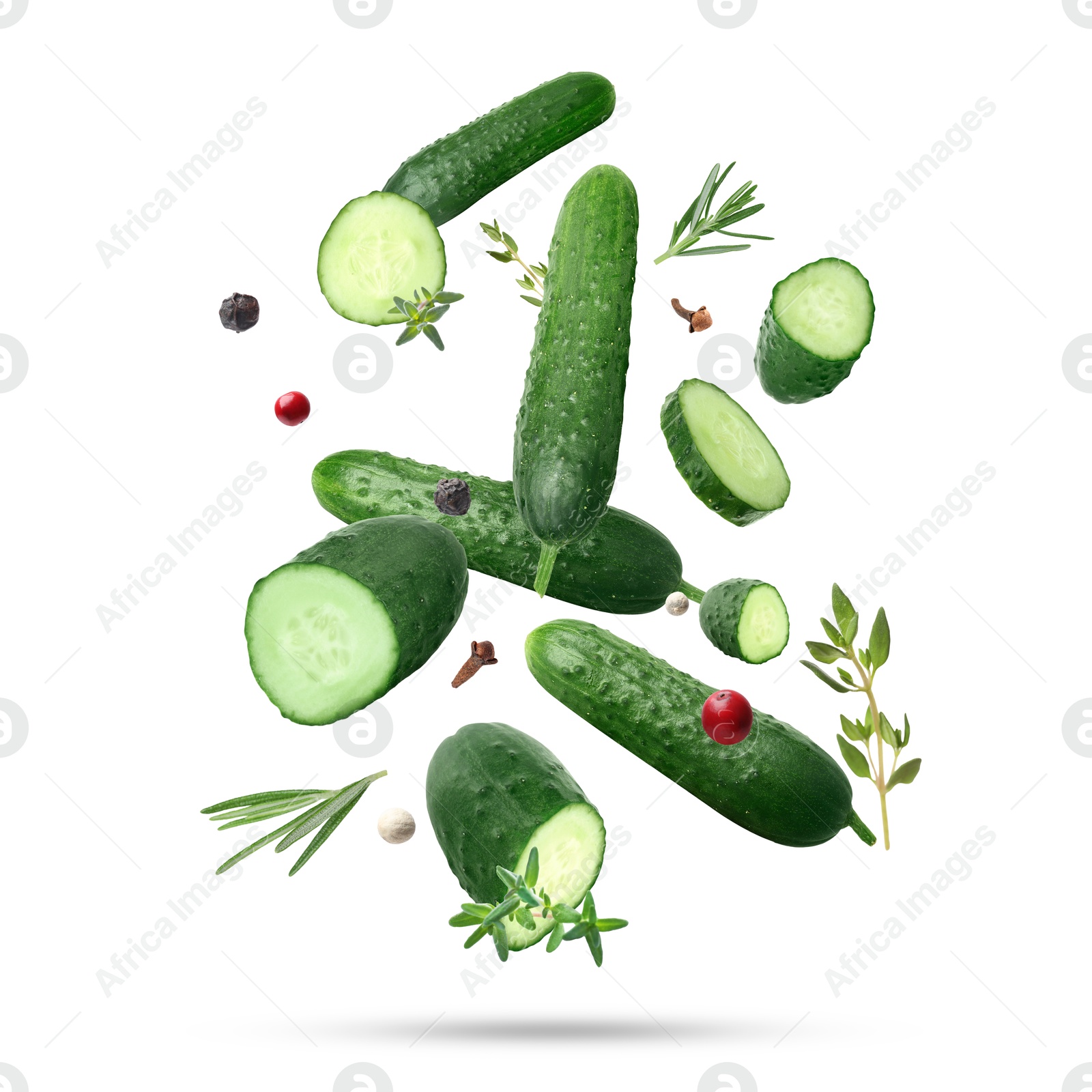 Image of Ripe cucumbers, herbs and spices falling on white background