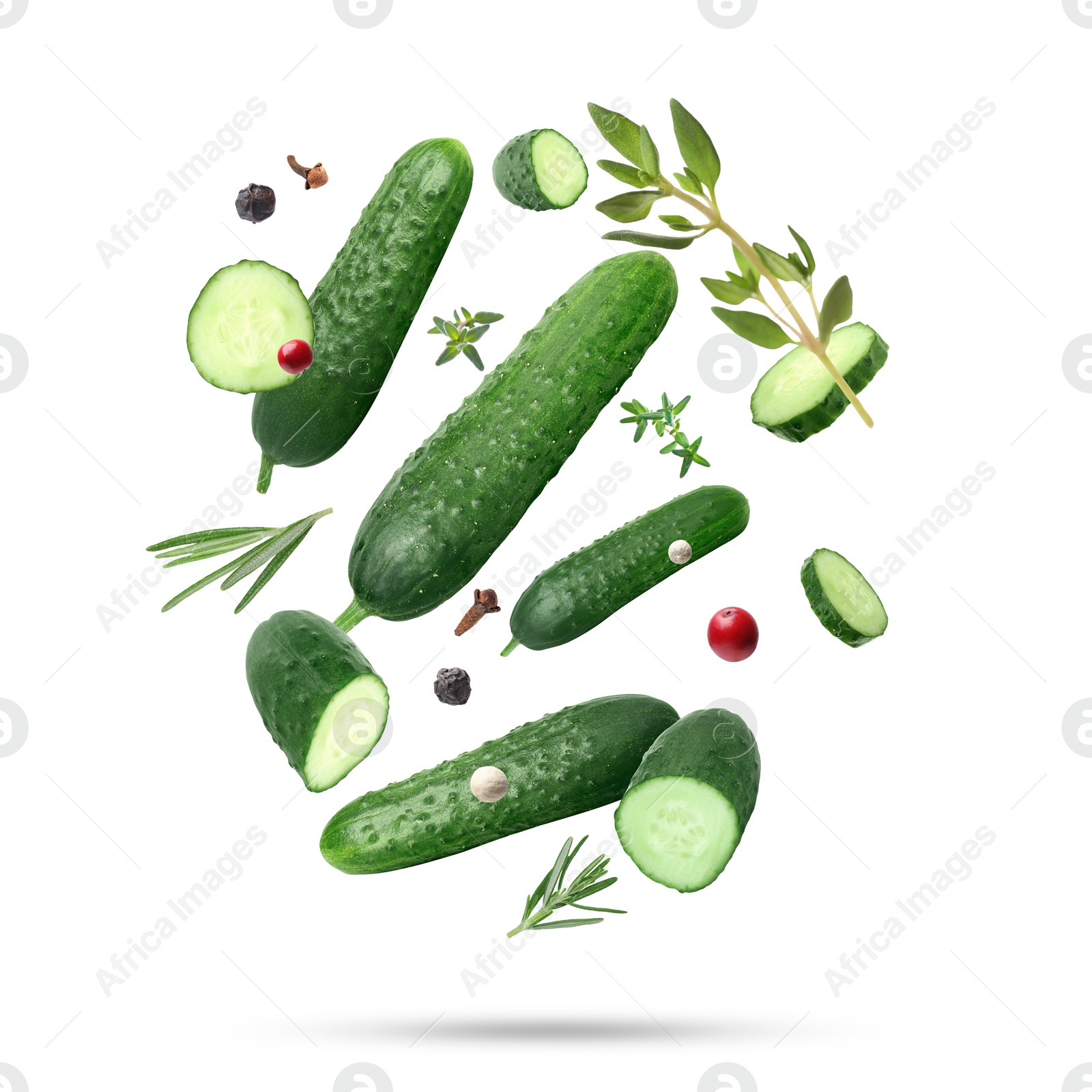 Image of Ripe cucumbers, herbs and spices falling on white background