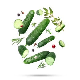 Image of Ripe cucumbers, herbs and spices falling on white background