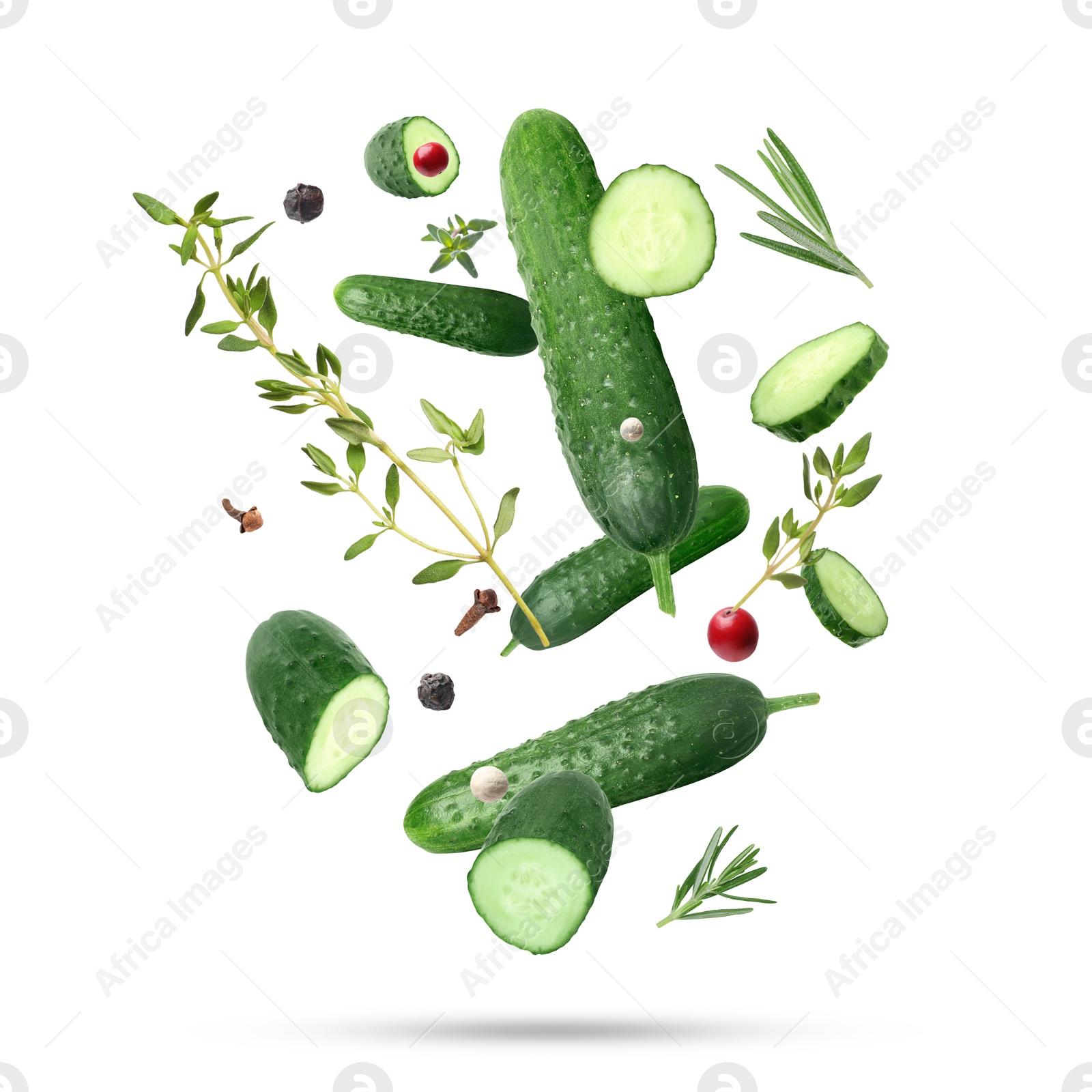 Image of Ripe cucumbers, herbs and spices falling on white background