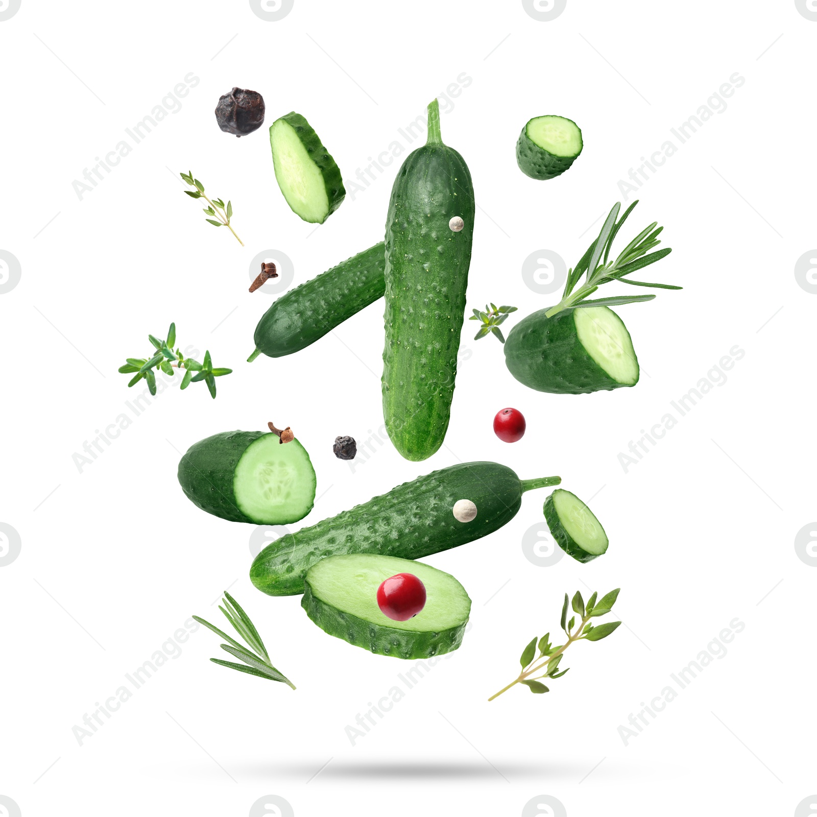 Image of Ripe cucumbers, herbs and spices falling on white background