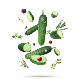 Image of Ripe cucumbers, herbs and spices falling on white background