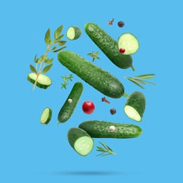 Image of Ripe cucumbers, herbs and spices falling on light blue background