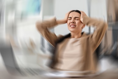 Image of Woman suffering from headache indoors, motion blur effect