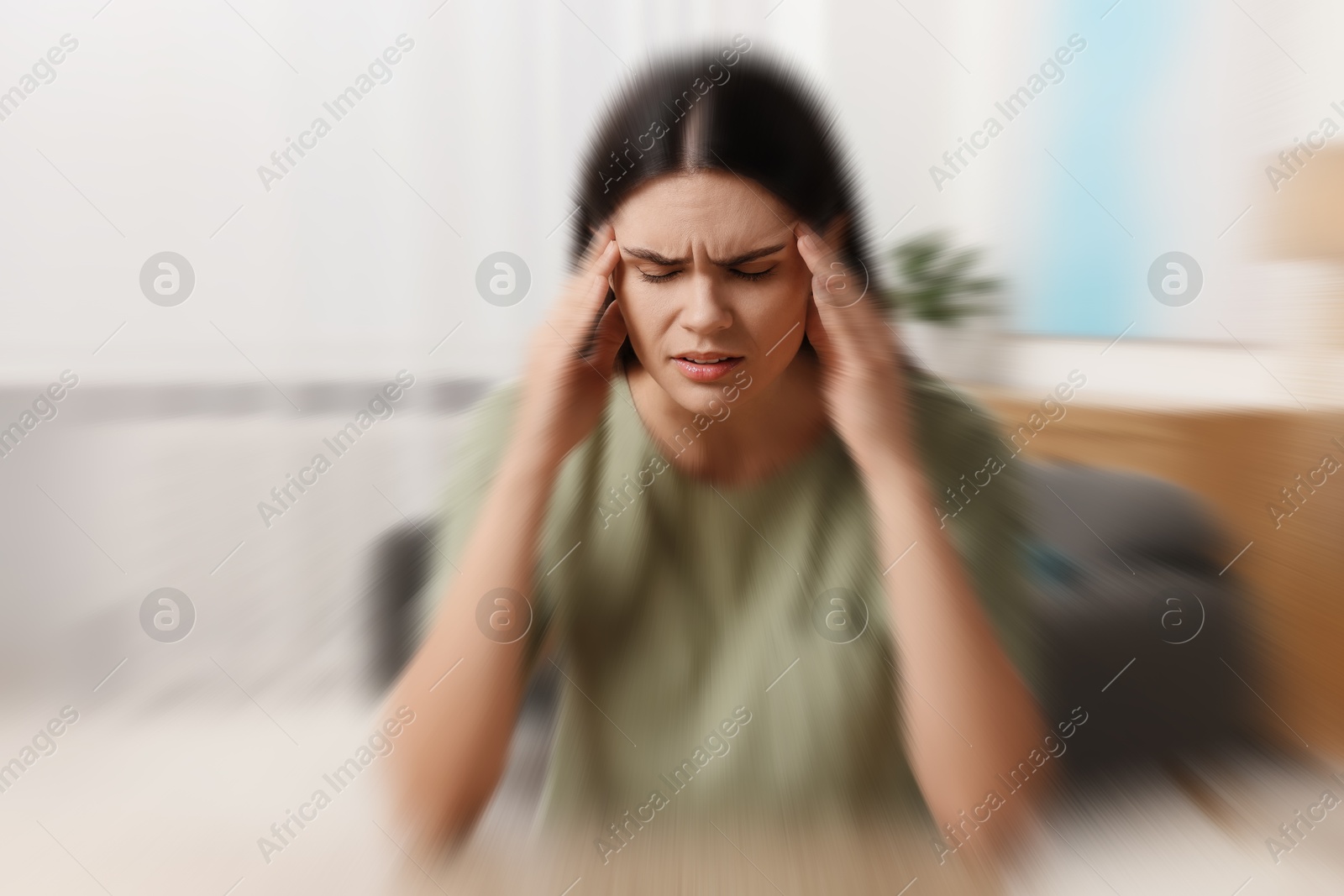 Image of Woman suffering from headache indoors, motion blur effect