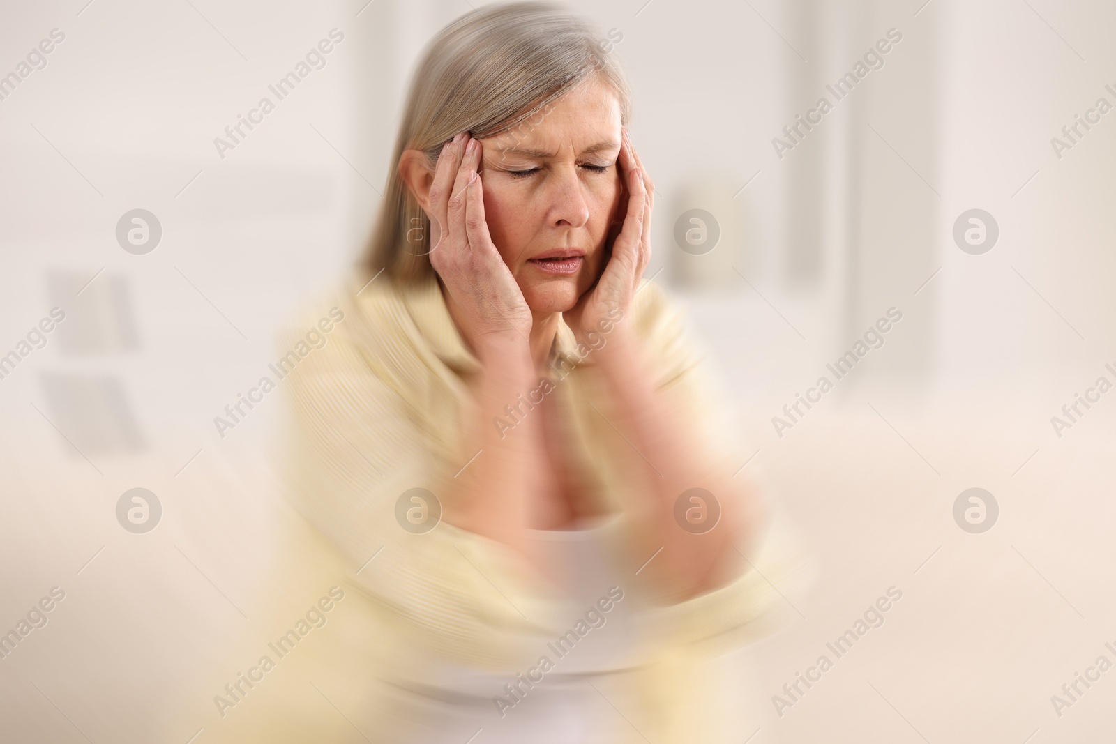 Image of Senior woman suffering from headache indoors, motion blur effect