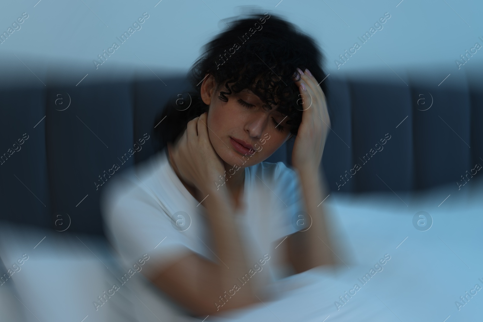 Image of Woman suffering from headache in bed, motion blur effect