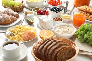 Photo of Tasty breakfast. Many different food and drinks on light table