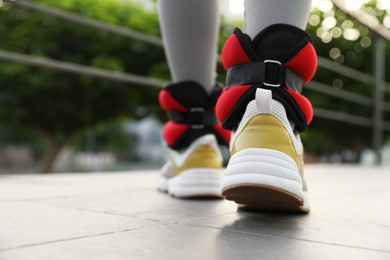 Photo of Woman with ankle weights walking outdoors, closeup