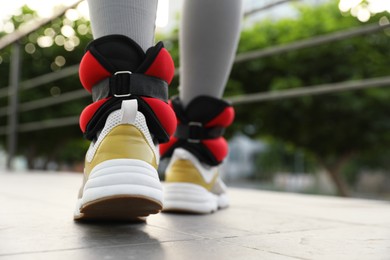 Woman with ankle weights walking outdoors, closeup