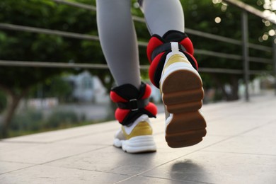 Woman with ankle weights walking outdoors, closeup