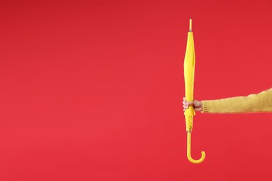 Photo of Woman with yellow umbrella on red background, closeup. Space for text