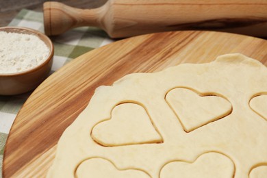 Photo of Raw dough and rolling pin on table, closeup