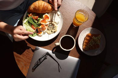 Photo of Man having tasty breakfast in cafe, top view