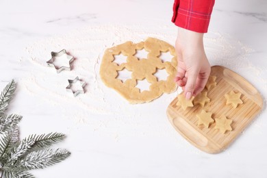 Making cookies. Woman with unbaked dough stars at white marble table, closeup