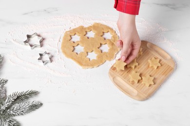 Photo of Making cookies. Woman with unbaked dough stars at white marble table, closeup