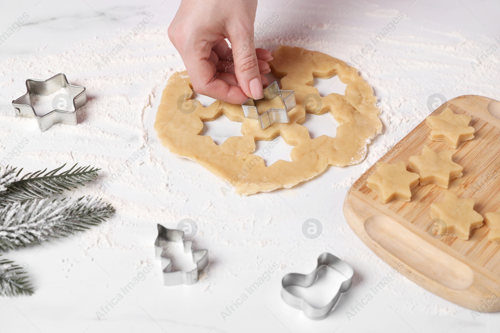 Photo of Woman making cookies with cutters at white marble table, closeup