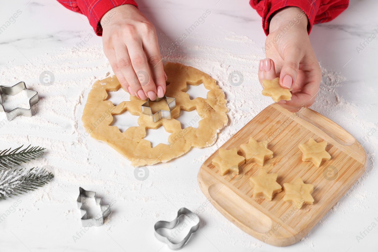 Photo of Woman making cookies with cutters at white marble table, closeup