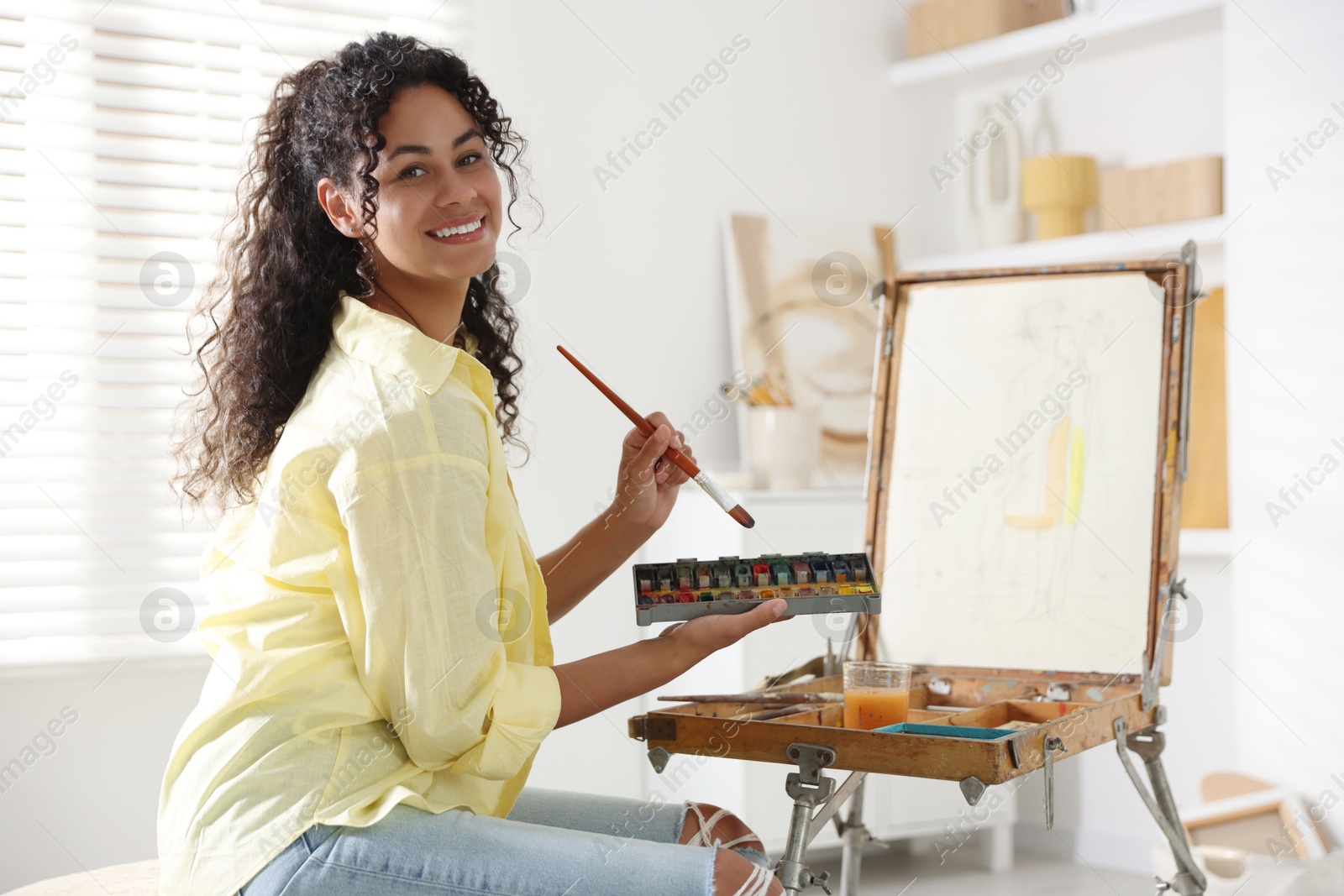 Photo of Smiling woman drawing picture in art studio