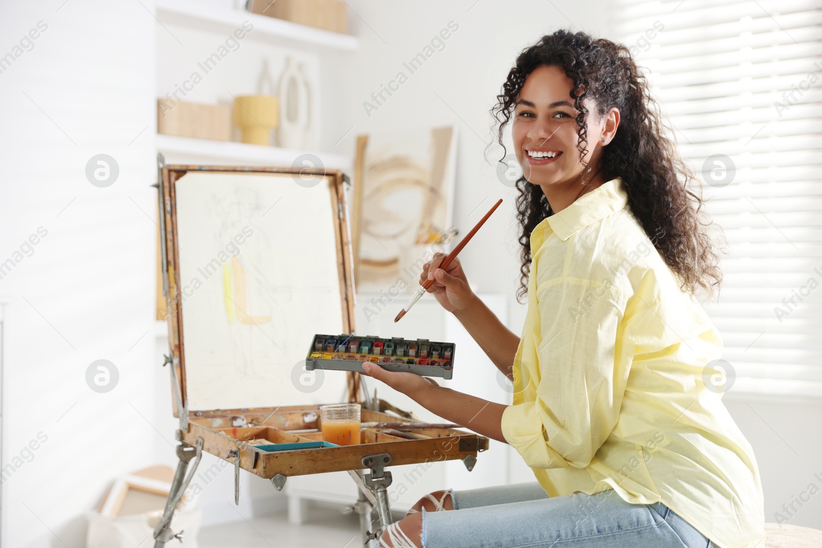 Photo of Smiling woman drawing picture in art studio