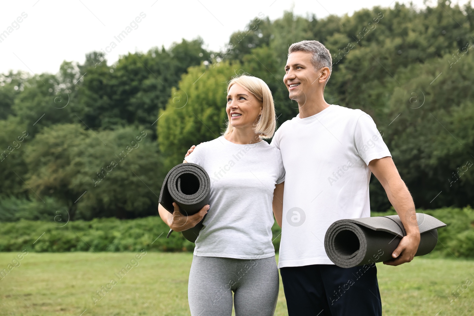 Photo of Happy couple with yoga mats in park