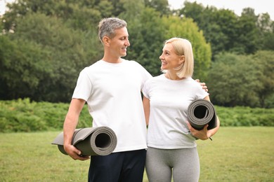 Photo of Happy couple with yoga mats in park