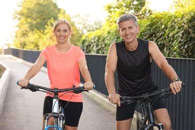 Photo of Happy couple with bicycles in park. Healthy lifestyle