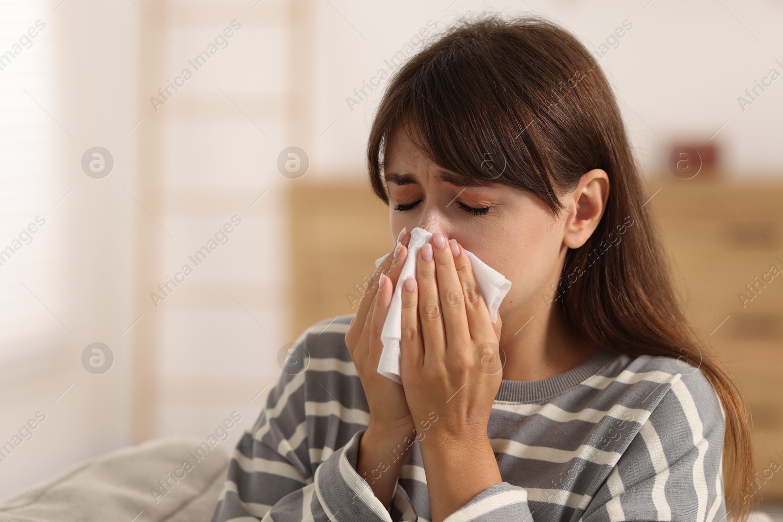 Photo of Woman with napkin suffering from sinusitis at home. Space for text