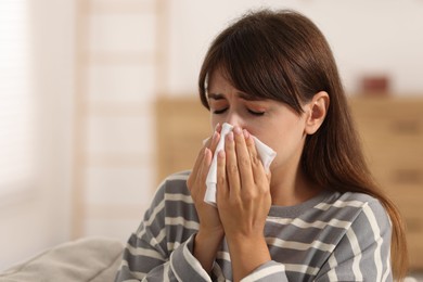 Photo of Woman with napkin suffering from sinusitis at home. Space for text