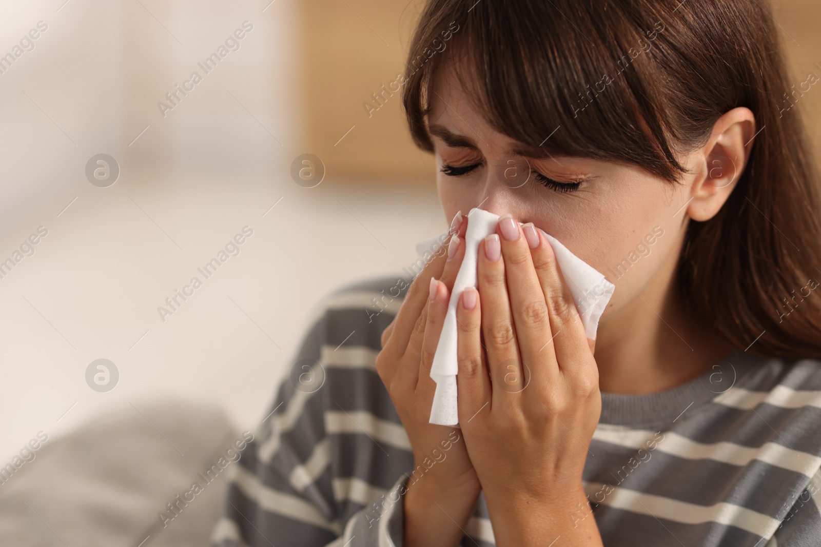 Photo of Woman with napkin suffering from sinusitis at home. Space for text