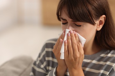 Photo of Woman with napkin suffering from sinusitis at home. Space for text