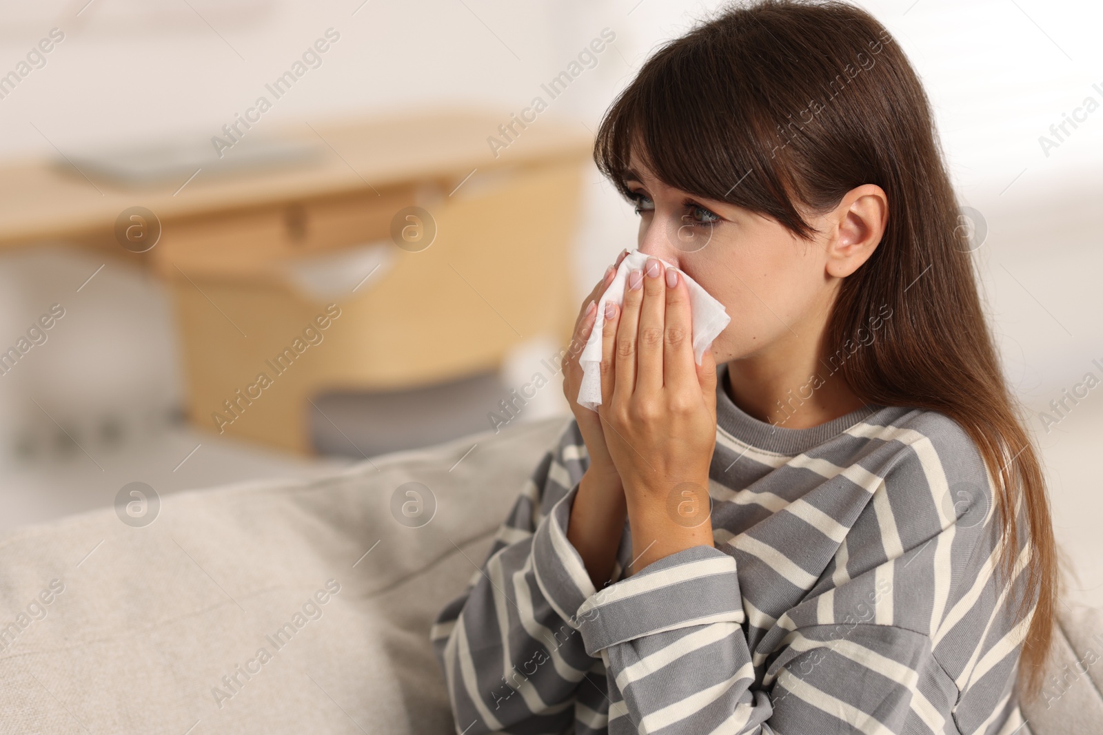 Photo of Woman with napkin suffering from sinusitis at home. Space for text