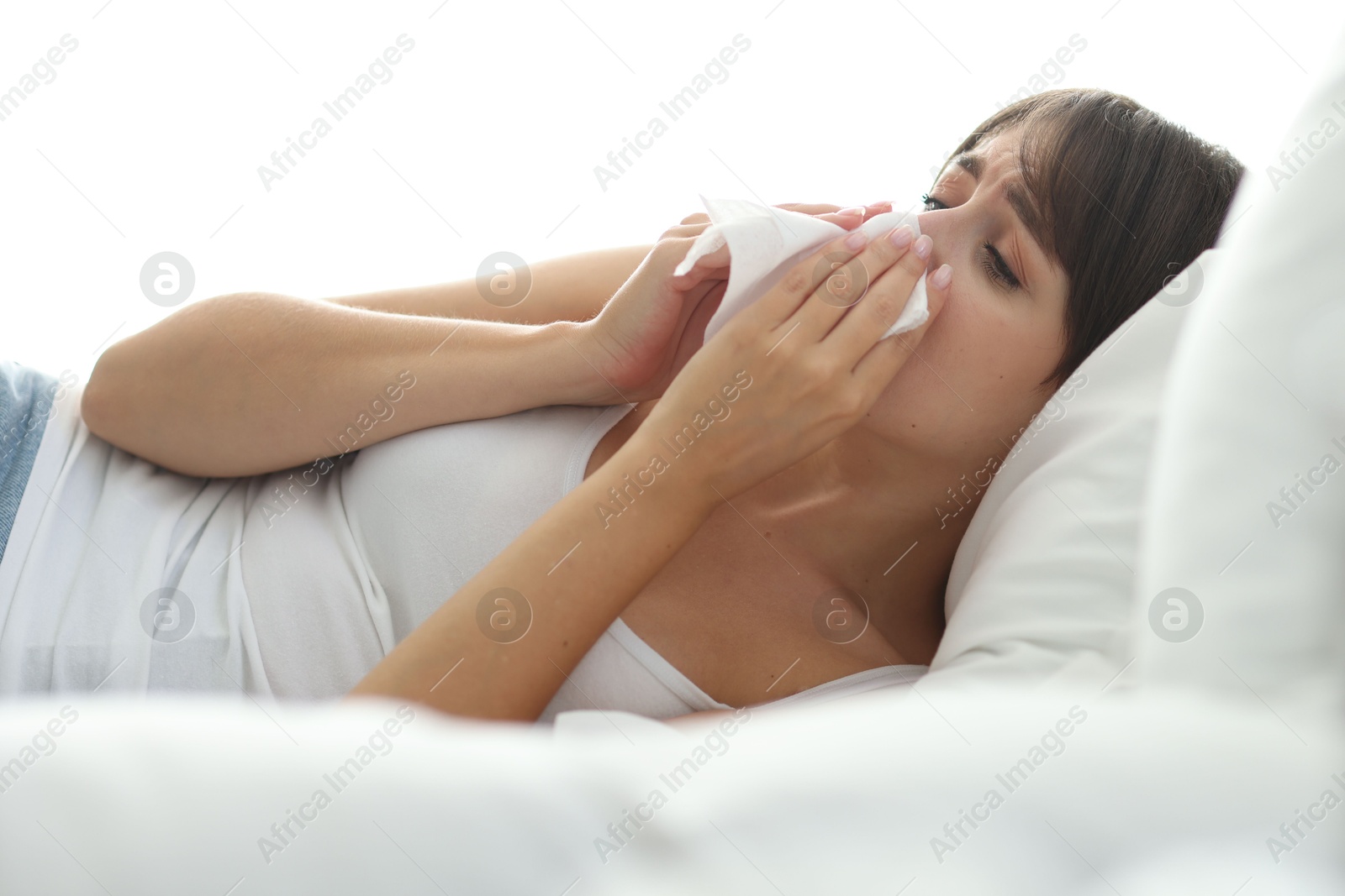 Photo of Woman with napkin suffering from sinusitis on bed