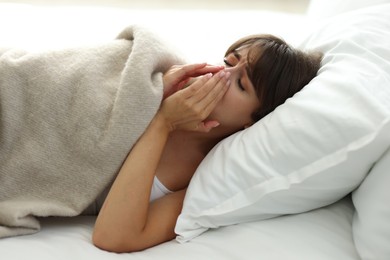 Woman suffering from sinusitis in bed indoors