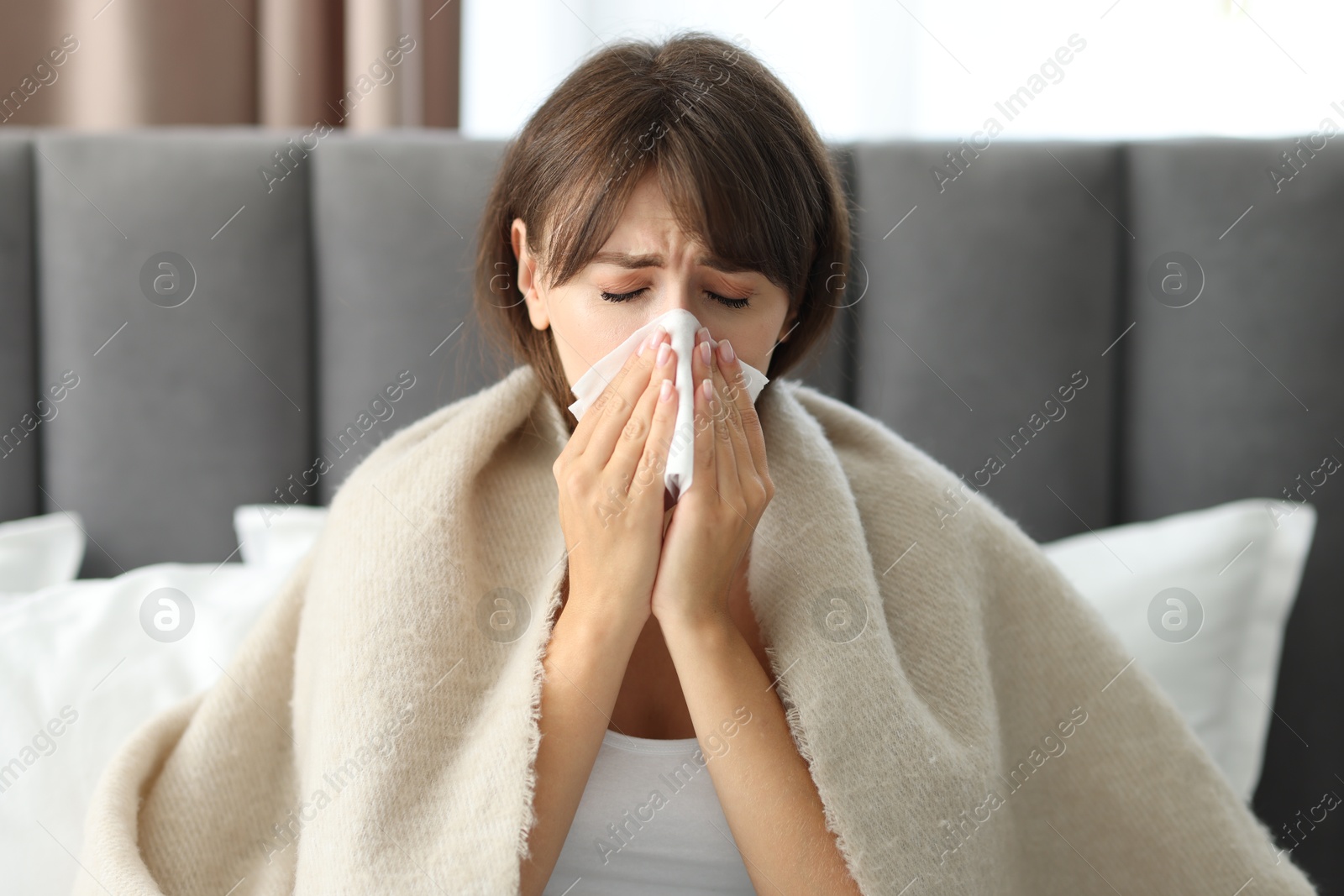 Photo of Woman wrapped in blanket suffering from sinusitis at home