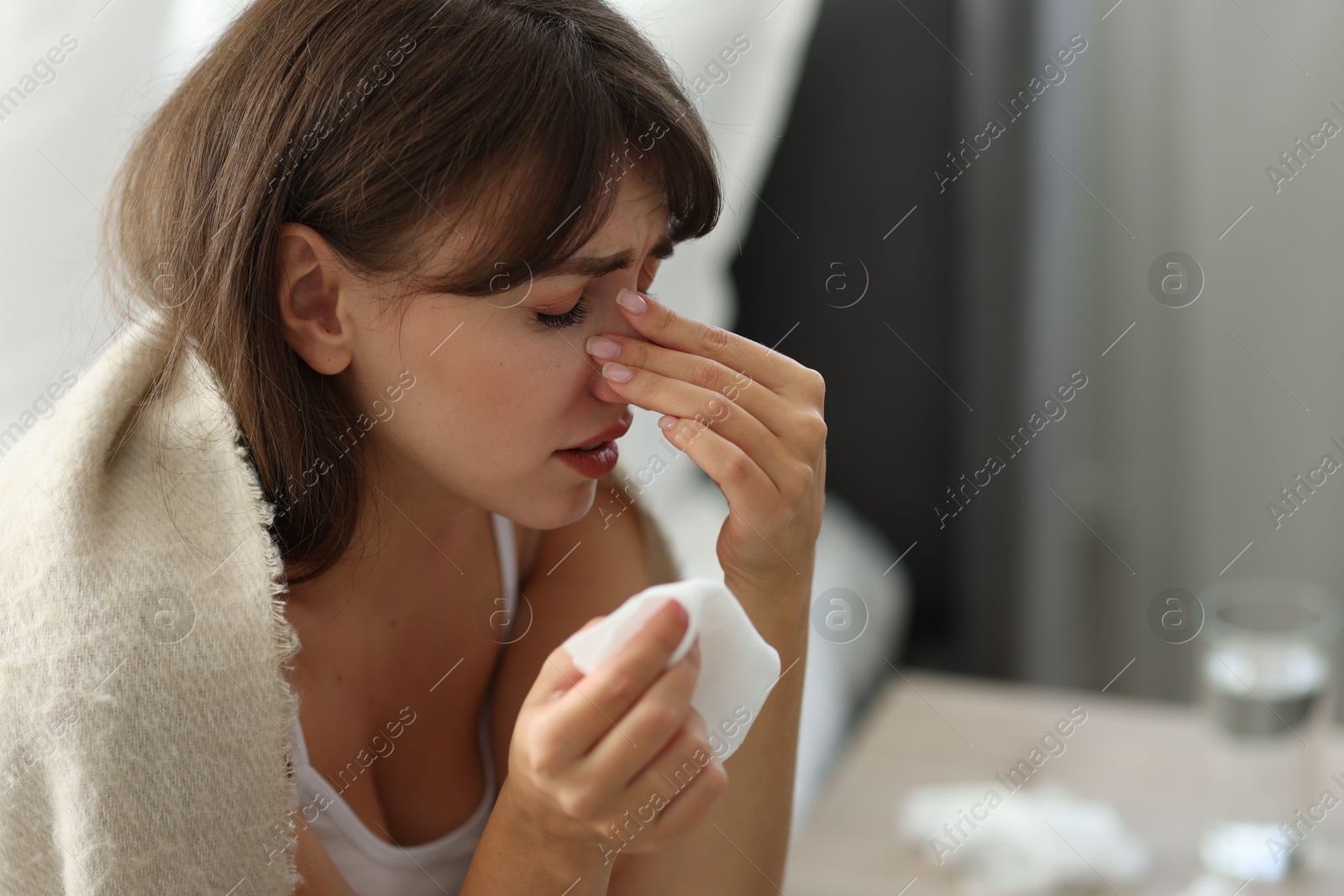 Photo of Woman wrapped in blanket suffering from sinusitis at home. Space for text