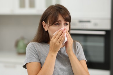 Photo of Woman with napkin suffering from sinusitis at home