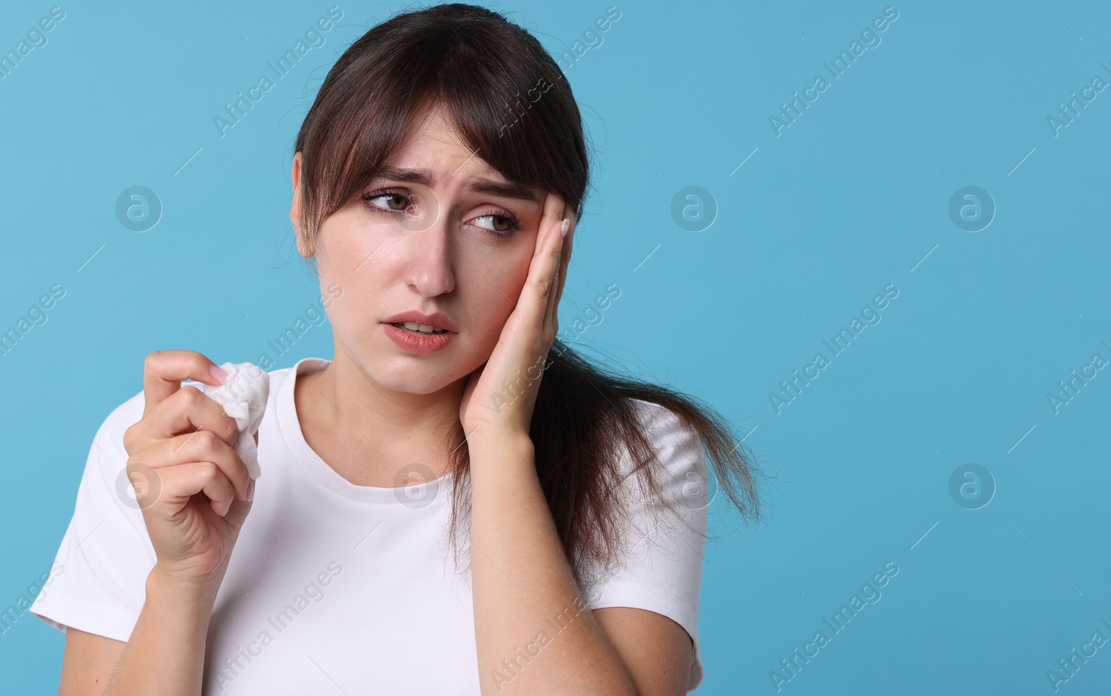 Photo of Woman with napkin suffering from sinusitis on light blue background. Space for text