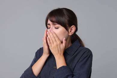 Woman suffering from sinusitis on grey background