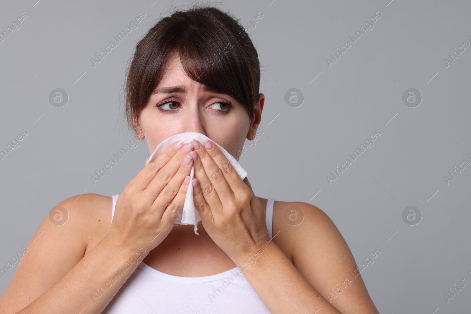 Photo of Woman with napkin suffering from sinusitis on grey background