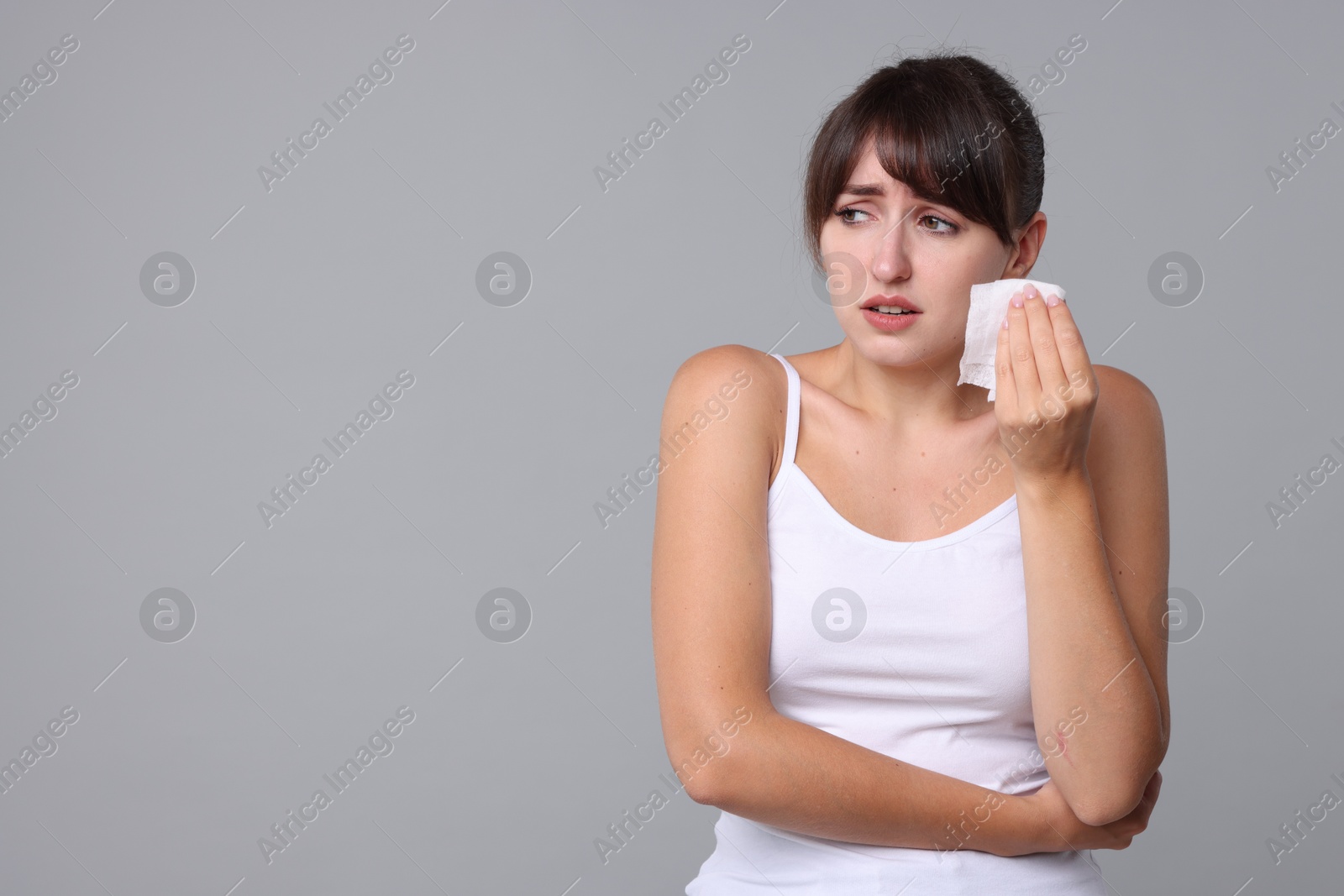 Photo of Woman with napkin suffering from sinusitis on grey background. Space for text