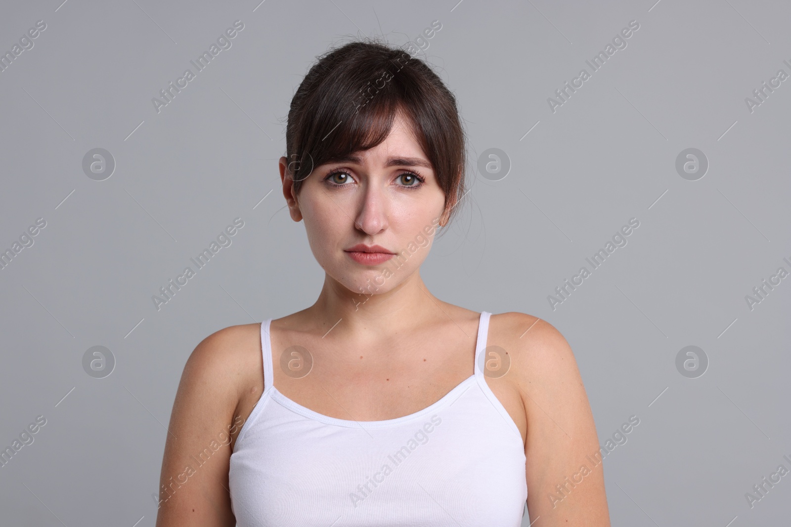 Photo of Portrait of frustrated woman on grey background