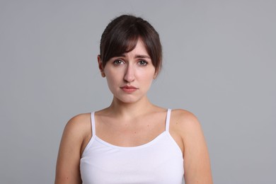 Photo of Portrait of frustrated woman on grey background