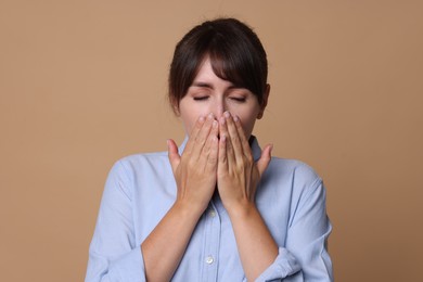 Woman suffering from sinusitis on beige background