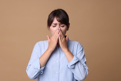 Photo of Woman suffering from sinusitis on beige background