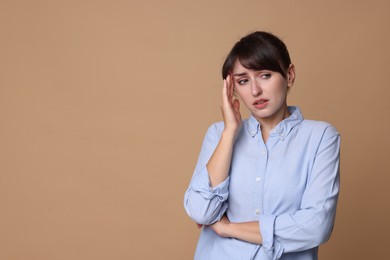 Photo of Woman suffering from sinusitis on beige background. Space for text