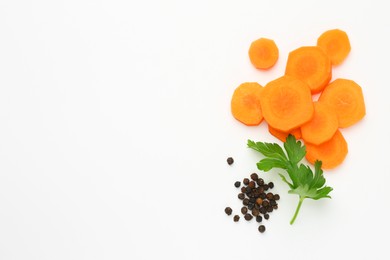 Photo of Pieces of fresh ripe carrot and spices on white background, flat lay. Space for text